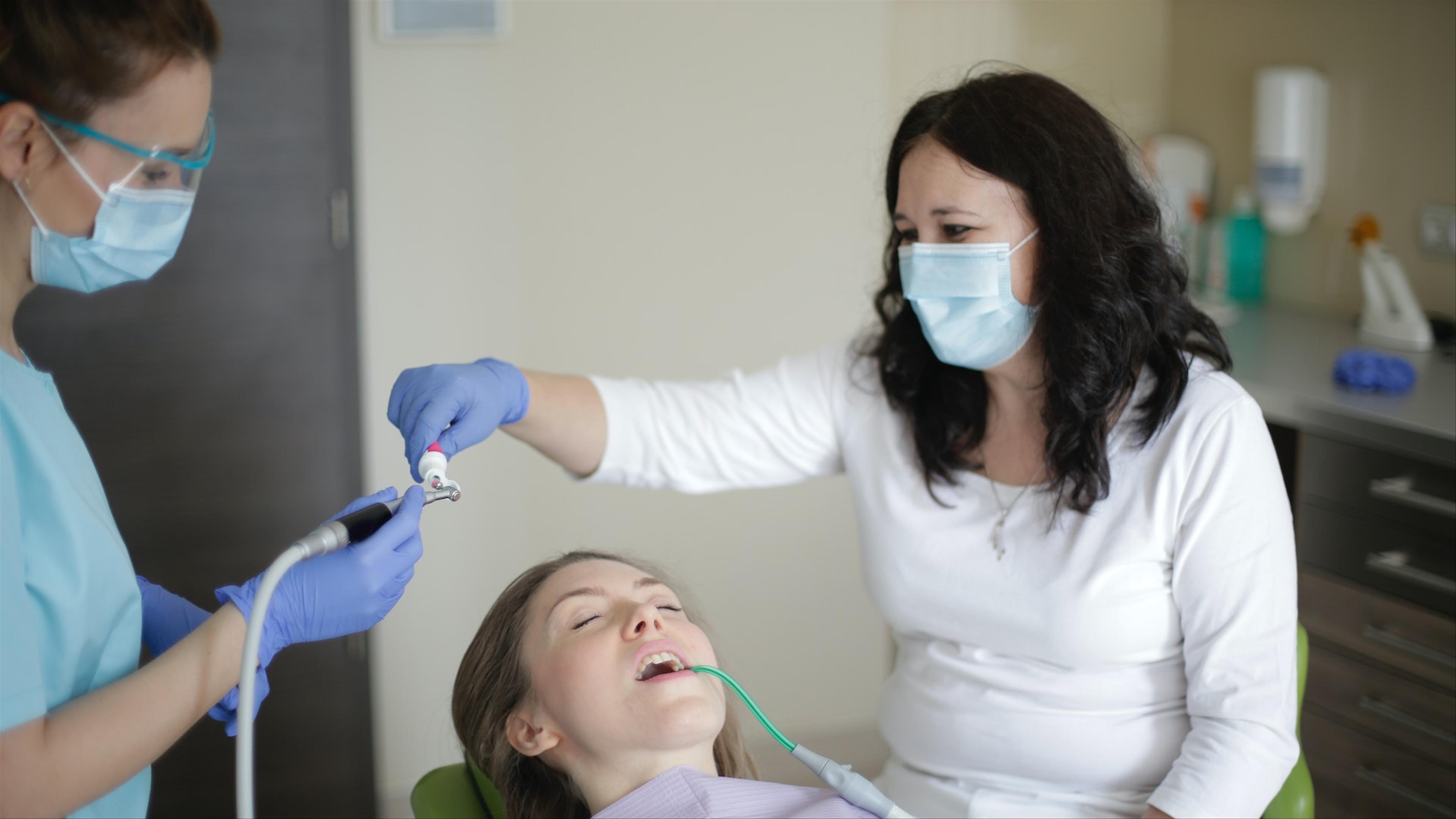 Dentist applying fluoride varnish at Klinik Pergigian T3